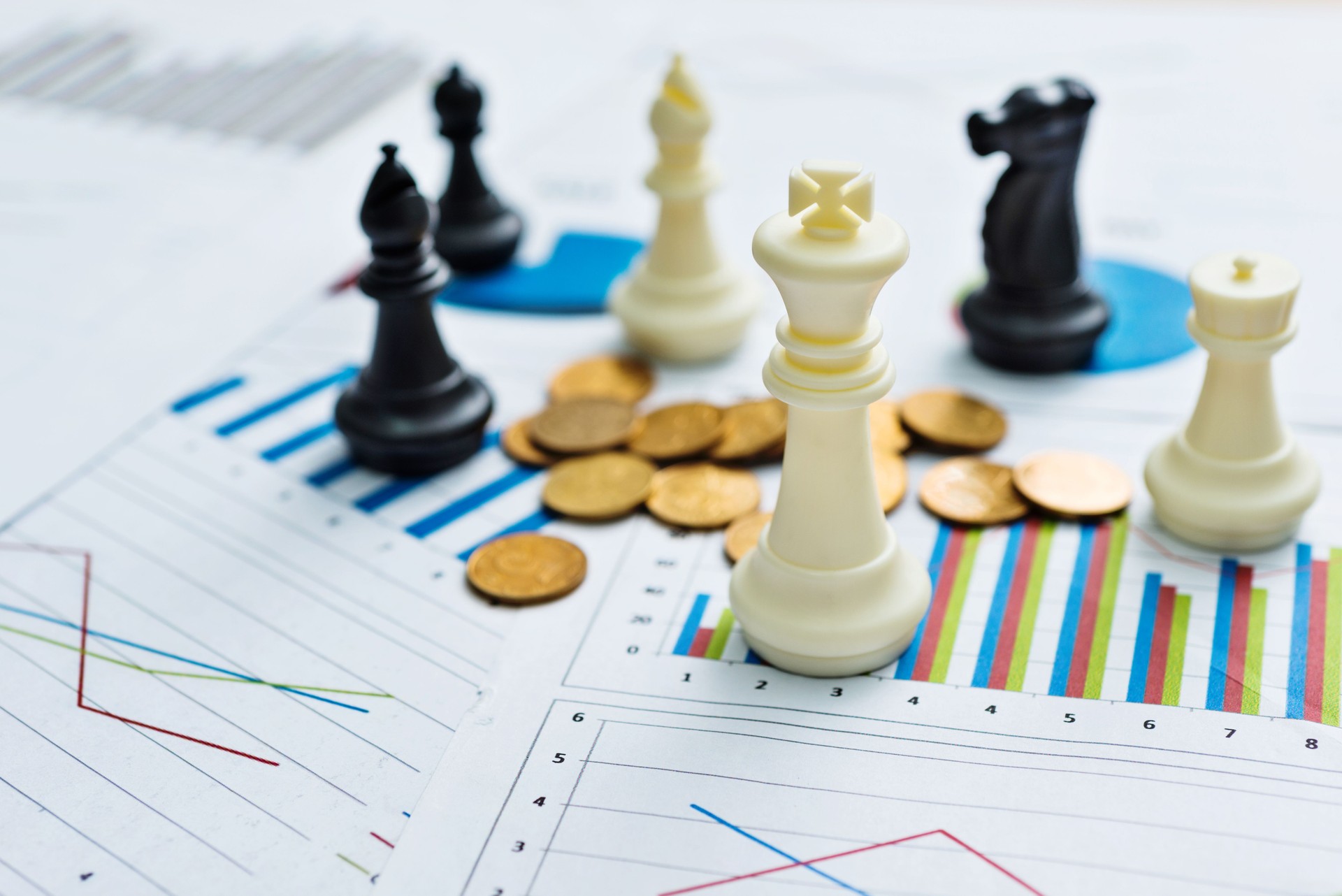 Chess pieces and coins on business chart background